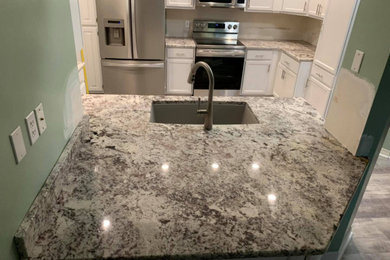Photo of a small traditional galley separate kitchen in New Orleans with an undermount sink, granite benchtops, with island and white benchtop.