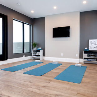 Foto di un ampio studio yoga design con pareti grigie, pavimento in legno massello medio e pavimento marrone