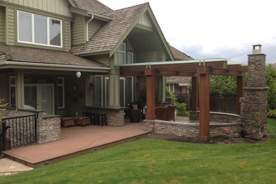 Example of a mid-sized transitional backyard patio design in Vancouver with a fire pit, decking and a pergola