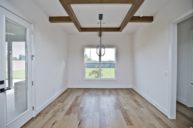 Example of a mid-sized classic medium tone wood floor and brown floor kitchen/dining room combo design in Other with white walls