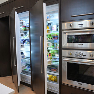 Large contemporary kitchen pantry designs - Example of a large trendy l-shaped light wood floor kitchen pantry design in Grand Rapids with a double-bowl sink, flat-panel cabinets, dark wood cabinets, solid surface countertops, white backsplash, stone slab backsplash, stainless steel appliances and an island