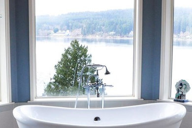 Inspiration for a mid-sized timeless master porcelain tile and gray floor freestanding bathtub remodel in Seattle with raised-panel cabinets, white cabinets, multicolored walls, an undermount sink, granite countertops and black countertops