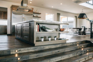Inspiration for a large contemporary l-shaped eat-in kitchen in San Diego with an undermount sink, stainless steel appliances, dark hardwood floors, with island, brown floor, shaker cabinets, dark wood cabinets and marble benchtops.