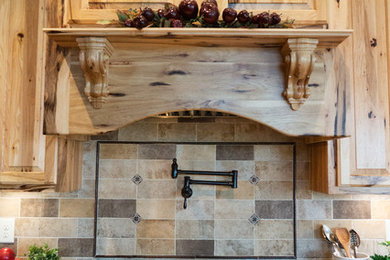 Eat-in kitchen - large cottage l-shaped medium tone wood floor and brown floor eat-in kitchen idea in St Louis with a double-bowl sink, raised-panel cabinets, light wood cabinets, quartzite countertops, multicolored backsplash, ceramic backsplash, stainless steel appliances, an island and brown countertops