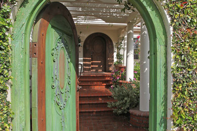 This is an example of an eclectic entryway in Los Angeles with a single front door and a green front door.