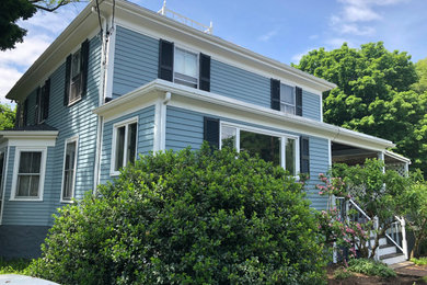 Example of a large 1950s blue two-story wood exterior home design in Boston with a tile roof