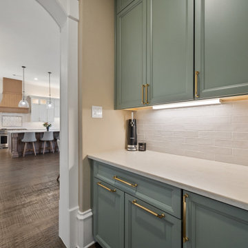 Built-in beverage center with sage green cabinets and under-cabinet lighting