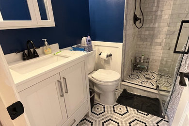 Bathroom - mid-sized contemporary master ceramic tile and single-sink bathroom idea in Philadelphia with furniture-like cabinets, white cabinets, a two-piece toilet, blue walls, quartz countertops, a hinged shower door, white countertops and a freestanding vanity