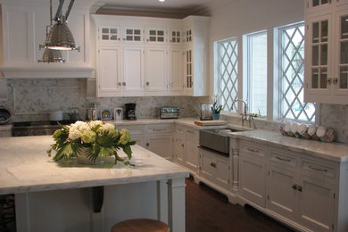 Open concept kitchen - large coastal u-shaped dark wood floor and brown floor open concept kitchen idea in New York with a farmhouse sink, shaker cabinets, white cabinets, marble countertops, white backsplash, marble backsplash, stainless steel appliances and an island