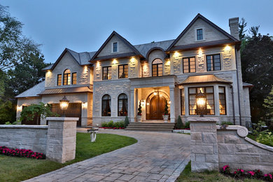 Photo of a traditional three-storey white house exterior in Toronto with stone veneer.