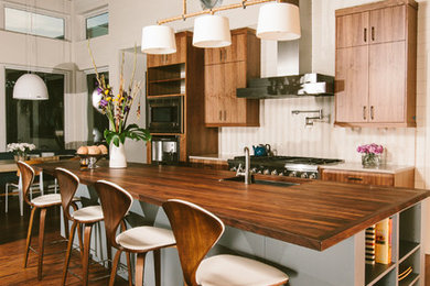Modern kitchen in Austin with wood benchtops.
