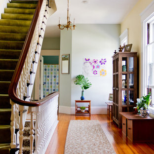 Esempio di un ingresso o corridoio chic con pareti grigie, pavimento in legno massello medio e pavimento arancione