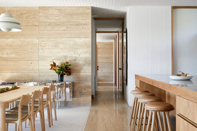 Photo of a mid-sized beach style open plan dining in Melbourne with beige walls, travertine floors, beige floor and timber.
