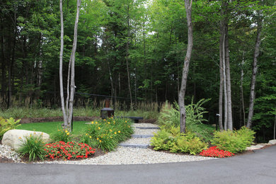 Photo of a contemporary front yard partial sun driveway for summer in Montreal with a fire feature and concrete pavers.