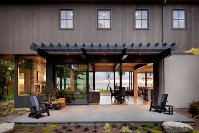 Immagine della villa country con rivestimento in legno, tetto a capanna, copertura in metallo o lamiera e tetto marrone