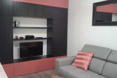 Cette image montre un petit salon design ouvert avec un mur blanc, un sol en bois brun, un téléviseur encastré et un sol marron.