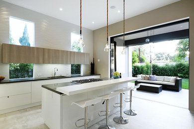 Example of a large trendy single-wall cement tile floor open concept kitchen design in Los Angeles with an undermount sink, flat-panel cabinets, white cabinets, solid surface countertops, stainless steel appliances and an island