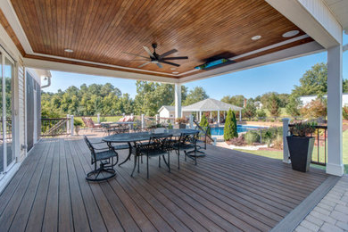 Inspiration for a large timeless backyard ground level deck remodel in Raleigh with a roof extension