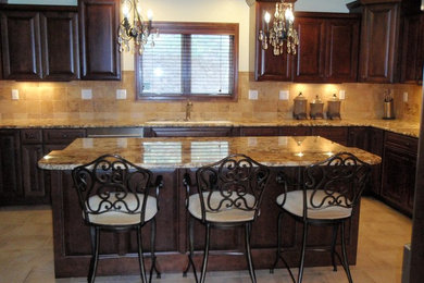 Large elegant l-shaped ceramic tile and beige floor eat-in kitchen photo in Denver with dark wood cabinets, beige backsplash, an island, raised-panel cabinets, granite countertops, ceramic backsplash and stainless steel appliances