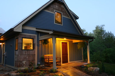 Photo of a mid-sized arts and crafts one-storey blue house exterior in Other with mixed siding and a gable roof.
