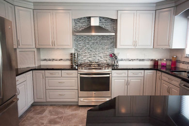 Inspiration for a contemporary porcelain tile kitchen remodel in Philadelphia with an undermount sink, white backsplash, mosaic tile backsplash, stainless steel appliances and an island