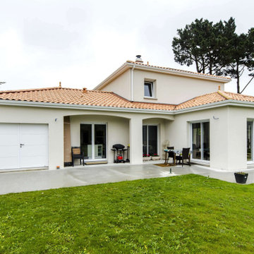 Maison en tuiles avec préau et arches cintrés