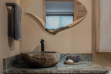 Example of a mid-sized mountain style blue tile and stone slab slate floor and gray floor powder room design in Denver with light wood cabinets, a one-piece toilet, beige walls, a vessel sink, quartzite countertops and blue countertops