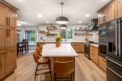 Mid-sized transitional l-shaped vinyl floor and beige floor eat-in kitchen photo in Other with a farmhouse sink, shaker cabinets, medium tone wood cabinets, quartz countertops, white backsplash, porcelain backsplash, black appliances, an island and white countertops