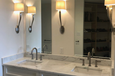 Design ideas for a mid-sized transitional master bathroom in New Orleans with recessed-panel cabinets, white cabinets, white walls, porcelain floors, an undermount sink, marble benchtops, white floor, multi-coloured benchtops, a double vanity and a built-in vanity.