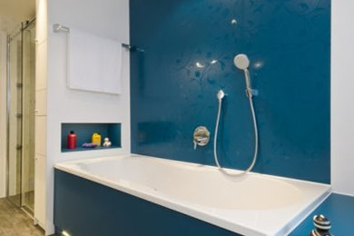 Modernes Duschbad mit Einbaubadewanne, bodengleicher Dusche, weißer Wandfarbe und braunem Boden in München