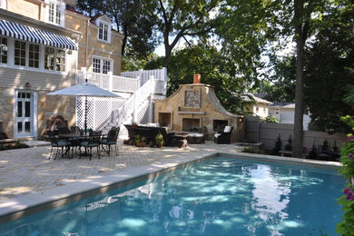 Large backyard rectangular lap pool in Chicago with concrete pavers.
