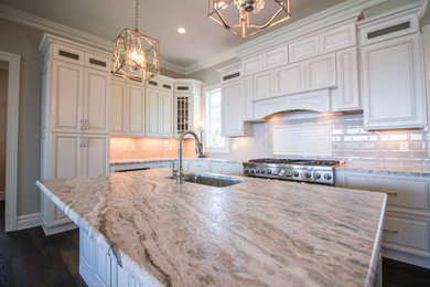 Photo of a large traditional u-shaped kitchen in New York with raised-panel cabinets, white cabinets, stainless steel appliances and with island.