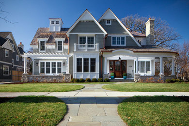This is an example of a large traditional two-storey grey exterior in Chicago with wood siding and a gable roof.