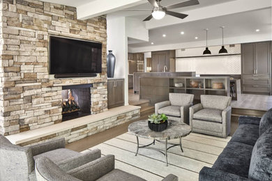 Inspiration for a medium sized contemporary open plan living room in Dallas with multi-coloured walls, medium hardwood flooring, a two-sided fireplace, a stacked stone fireplace surround, a wall mounted tv, brown floors and exposed beams.