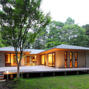 他の地域のアジアンスタイルのおしゃれな家の外観 (石材サイディング、ベージュの外壁、寄棟屋根、戸建、金属屋根) の写真