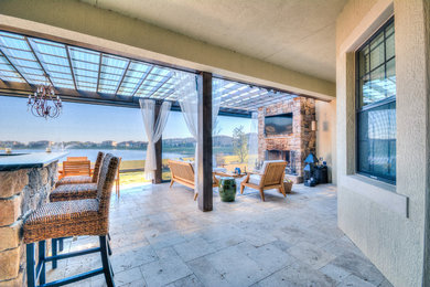 Example of a large transitional backyard stone patio design in Orlando with a fire pit and a roof extension