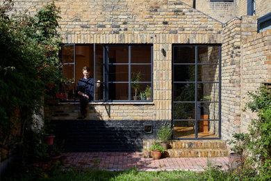 Modelo de fachada de casa tradicional de tamaño medio de dos plantas con revestimiento de ladrillo