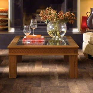 Photo of a medium sized mediterranean formal enclosed living room in New York with yellow walls, laminate floors, a standard fireplace and a brick fireplace surround.