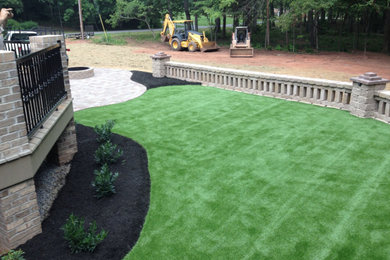 Inspiration for a large contemporary drought-tolerant and full sun backyard concrete paver retaining wall landscape in Raleigh.