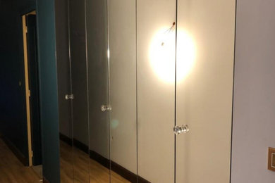 Diseño de armario vestidor unisex moderno extra grande con armarios con paneles lisos y suelo marrón