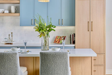 Kitchen - large traditional light wood floor kitchen idea in Toronto with a farmhouse sink, shaker cabinets, light wood cabinets, quartz countertops, white backsplash, ceramic backsplash, stainless steel appliances and white countertops