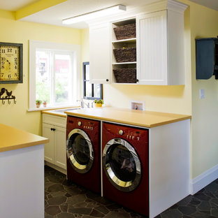 Photo of a small bohemian galley utility room in Vancouver with a built-in sink, shaker cabinets, white cabinets, laminate countertops, yellow walls, vinyl flooring, a side by side washer and dryer and yellow worktops.