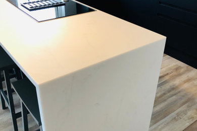 This is an example of a medium sized contemporary u-shaped open plan kitchen in London with composite countertops and white worktops.