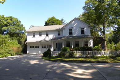 Example of a mid-sized white two-story vinyl exterior home design in Grand Rapids with a clipped gable roof