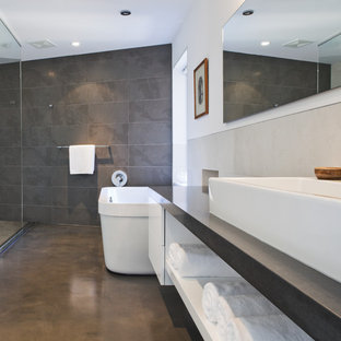 Immagine di una stanza da bagno moderna con vasca freestanding, lavabo a bacinella, pavimento in cemento, doccia aperta, doccia aperta e piastrelle in ardesia