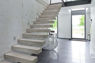 Design ideas for a mid-sized contemporary concrete floating staircase in Cologne with open risers.