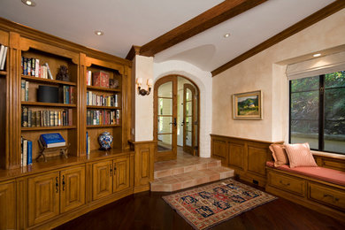 This is an example of a large mediterranean entryway in Santa Barbara with beige walls and dark hardwood floors.