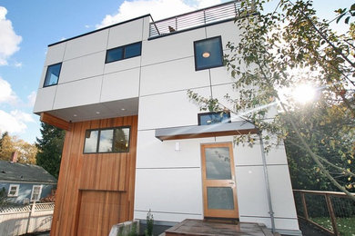 Mid-sized trendy gray mixed siding flat roof photo in Seattle