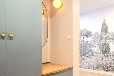 Modelo de hall actual de tamaño medio con paredes blancas, suelo de madera clara, suelo beige y papel pintado