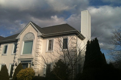Exempel på ett mellanstort klassiskt beige hus, med två våningar, stuckatur, valmat tak och tak i shingel